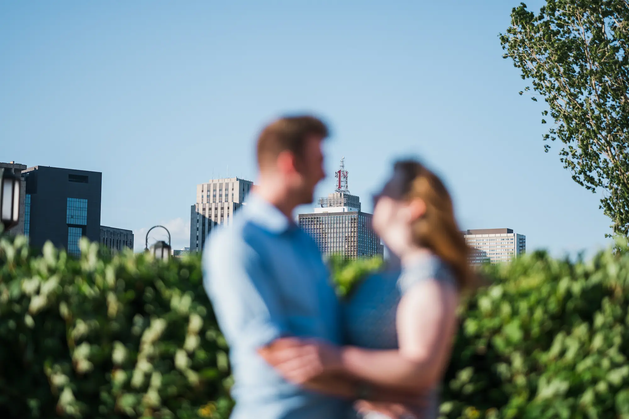 A blurry couple. In the distance, a clear shot of a skyscraper in Saint Paul